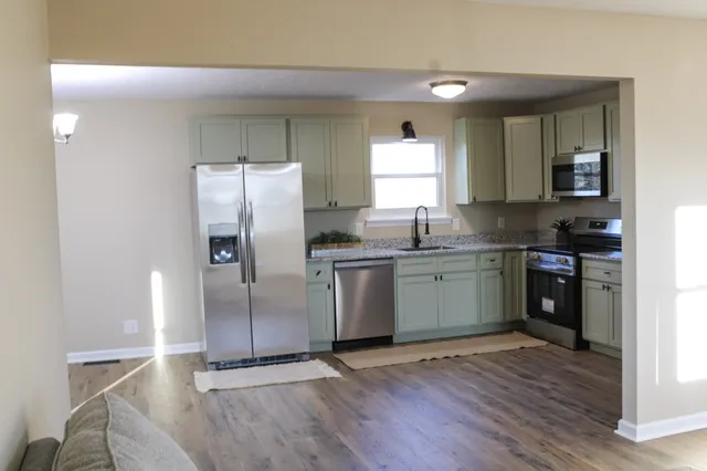 a kitchen with granite countertop a refrigerator and a sink