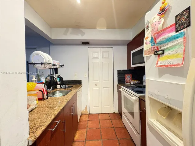 a kitchen with stainless steel appliances granite countertop a sink and a stove