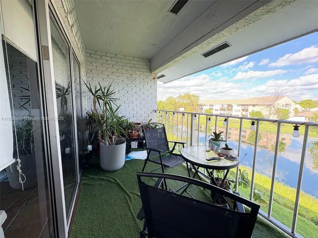 a view of a balcony with chairs and a potted plant