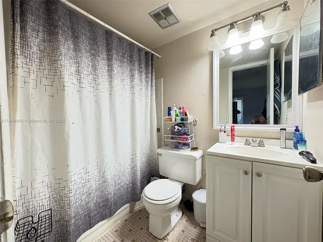 a bathroom with a sink a toilet and shower curtain