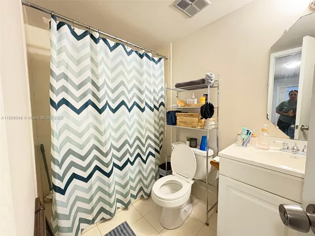 a bathroom with a sink toilet and shower curtain