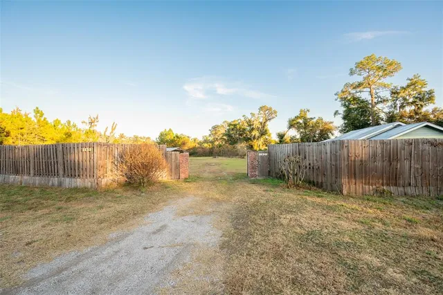 a view of backyard with wooden fence