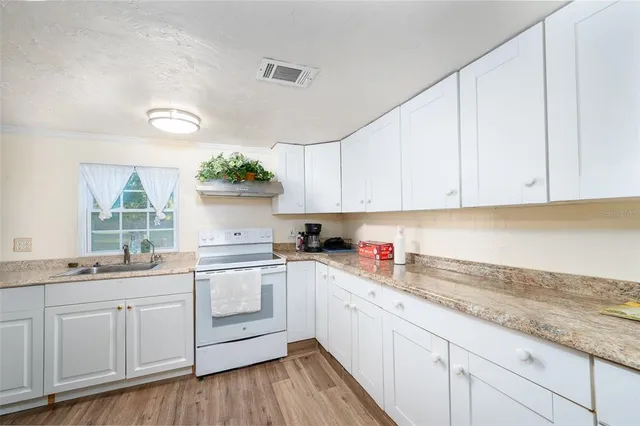 a kitchen with granite countertop white cabinets and white appliances