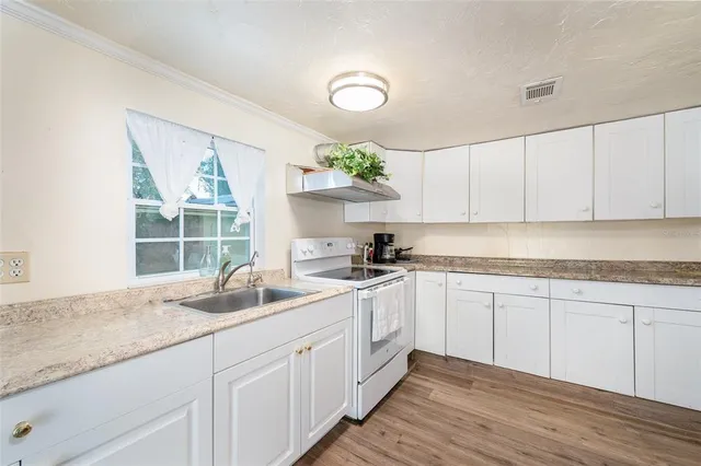 a kitchen with a sink cabinets and window