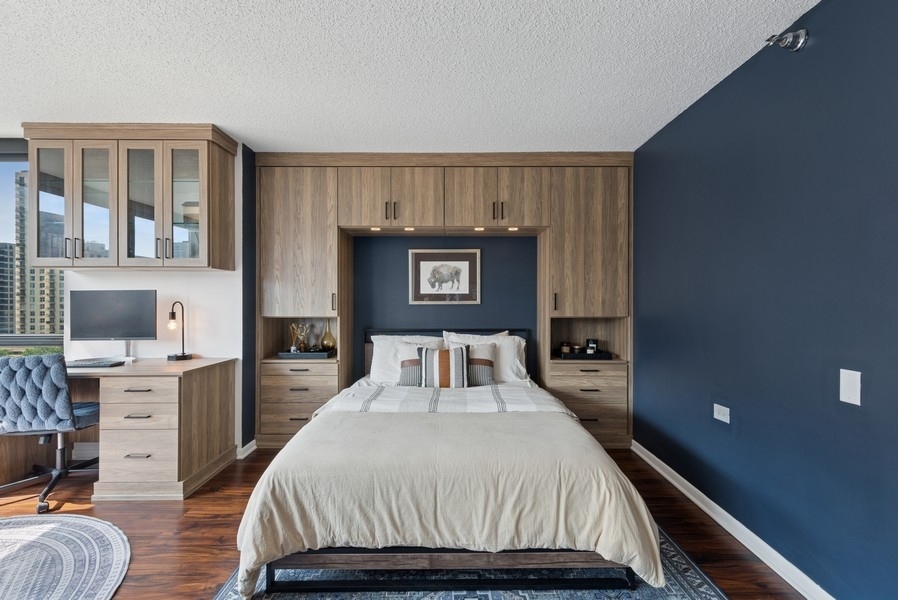 1122 North Clark Street, Unit 1002 Chicago, IL 60610 - Photo 12 of 14 a bedroom with a large bed and a desk