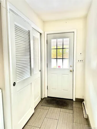 a view of a bedroom with wooden floor and a window