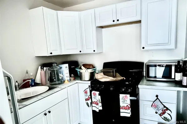 a kitchen with stainless steel appliances granite countertop a refrigerator and white cabinets