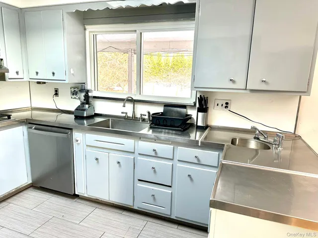 a kitchen with white cabinets and a sink