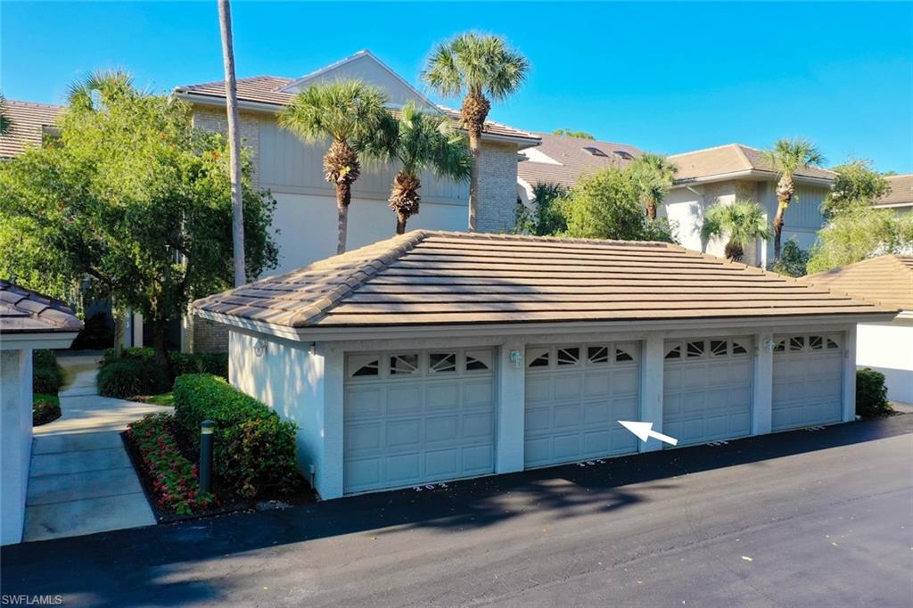 780 Waterford Drive, Unit 302 Naples, FL 34113 - Photo 21 of 47 a front view of a house with a garden