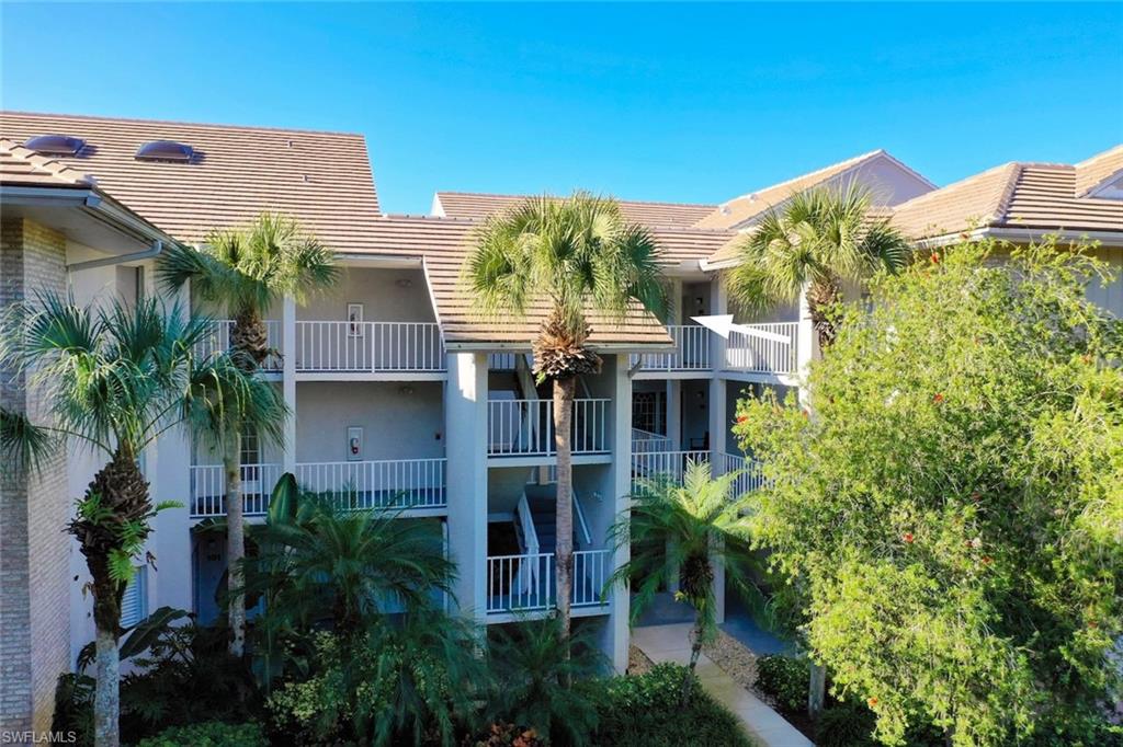 780 Waterford Drive, Unit 302 Naples, FL 34113 - Photo 22 of 47 a front view of a house with a yard