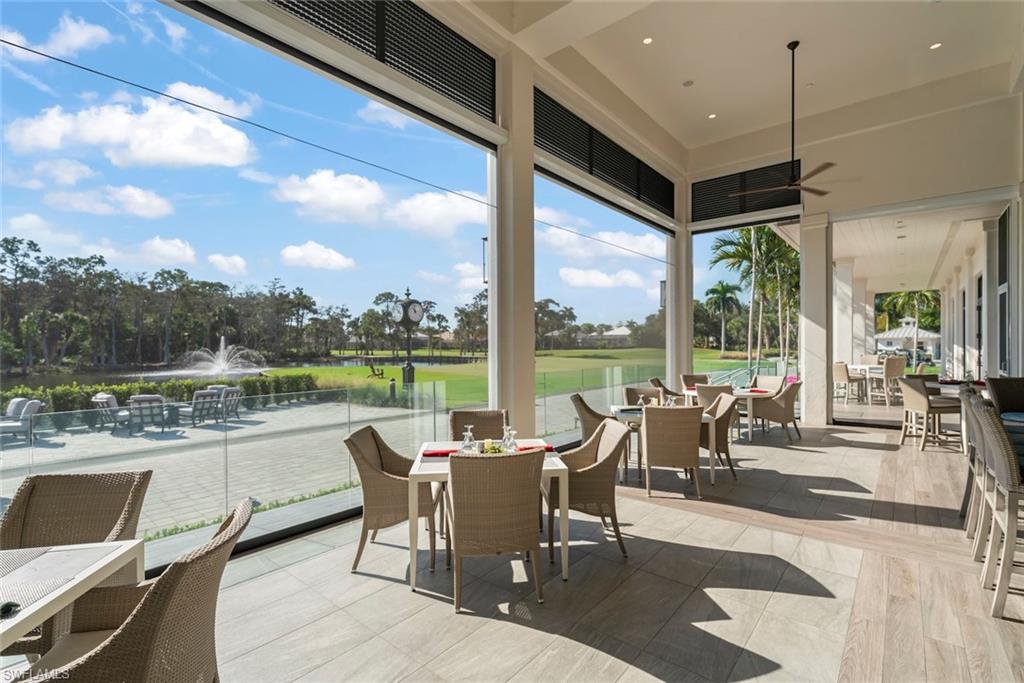 780 Waterford Drive, Unit 302 Naples, FL 34113 - Photo 41 of 47 a view of a dining room with furniture large windows and wooden floor