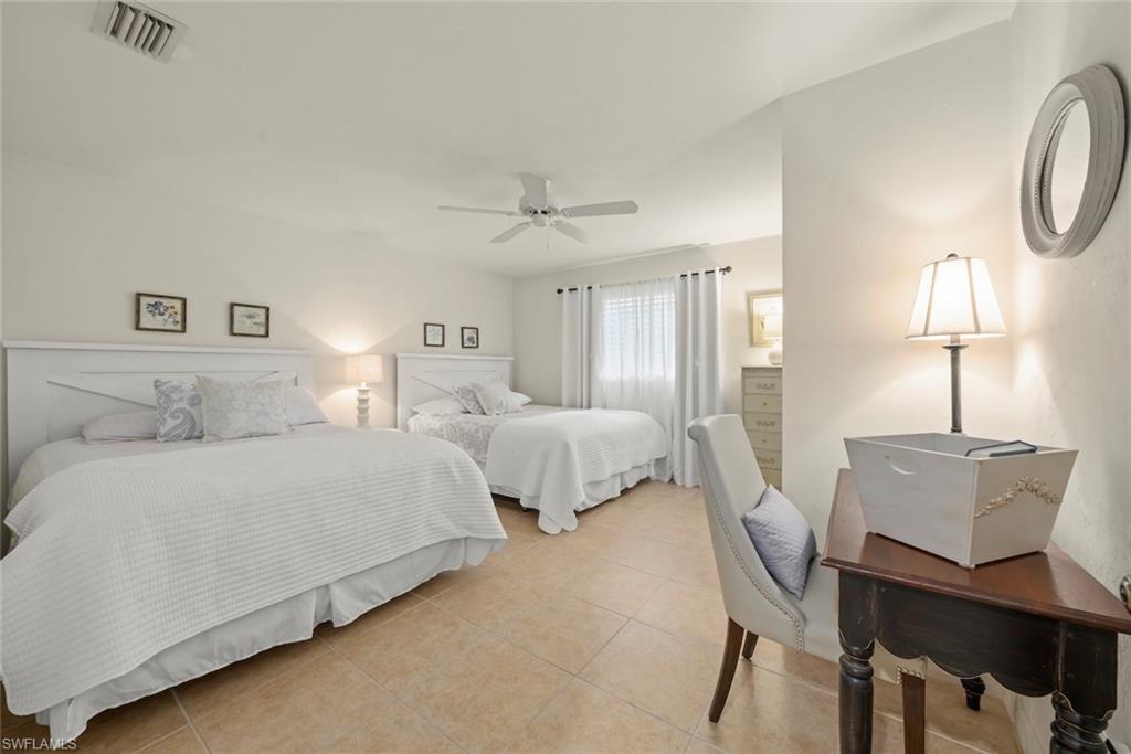 780 Waterford Drive, Unit 302 Naples, FL 34113 - Photo 6 of 47 a spacious bedroom with two beds and lamps
