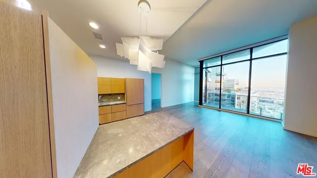 a view of a living room with wooden floor and a large window
