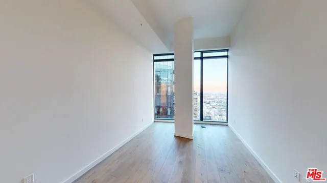 a view of an empty room with wooden floor and doors