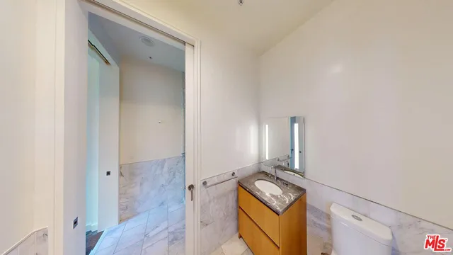 a bathroom with a granite countertop double vanity sink a mirror and a shower
