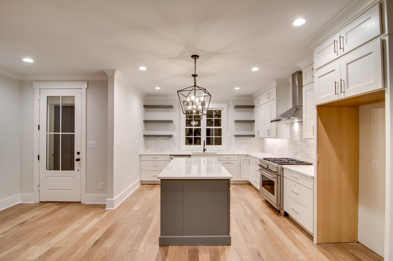 1006 Onslow Street Durham, NC 27705 - Photo 9 of 30 a kitchen with granite countertop wooden floors stainless steel appliances and white cabinets