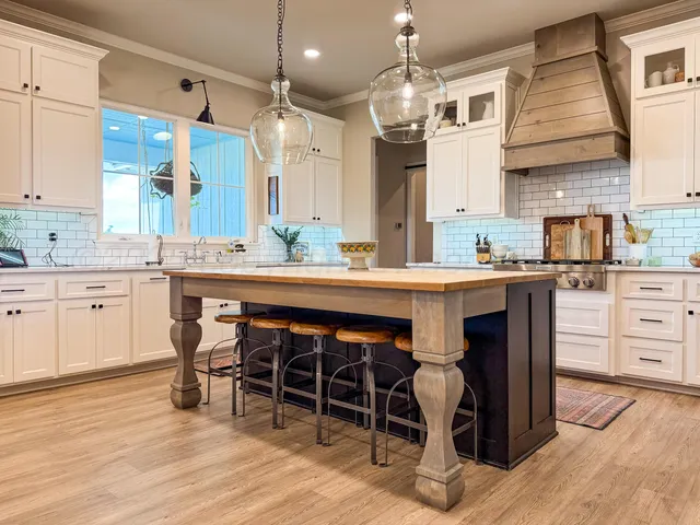 a kitchen with stainless steel appliances a dining table chairs and wooden floor