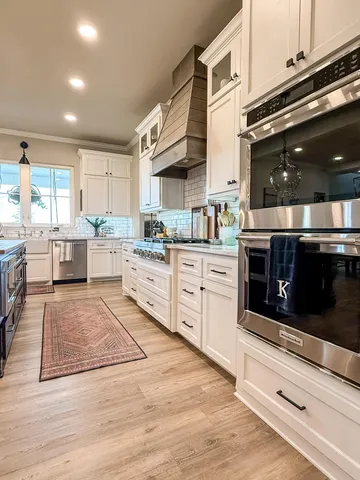 a kitchen with stainless steel appliances granite countertop a stove a sink and a microwave