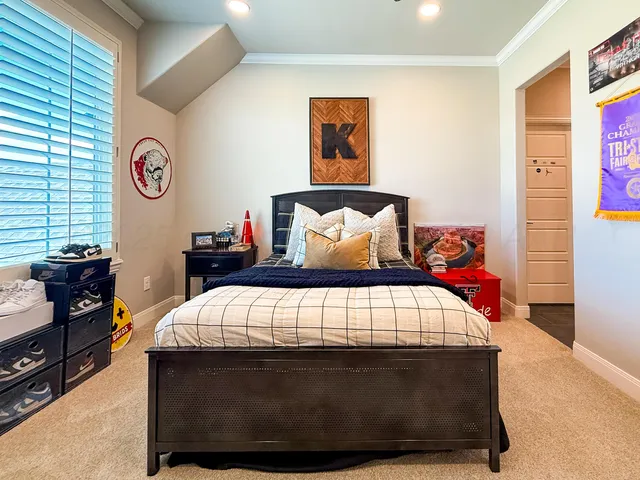a bedroom with a bed and a lamp on dresser