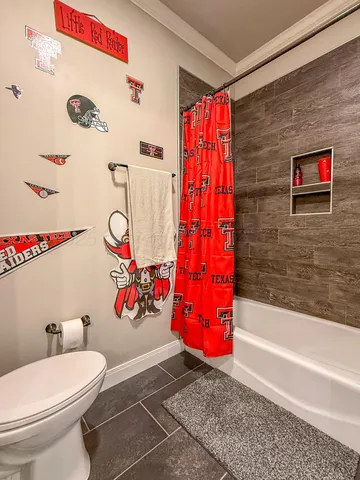 a bathroom with a toilet and a shower curtain