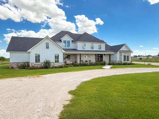 a front view of a house with a garden and yard