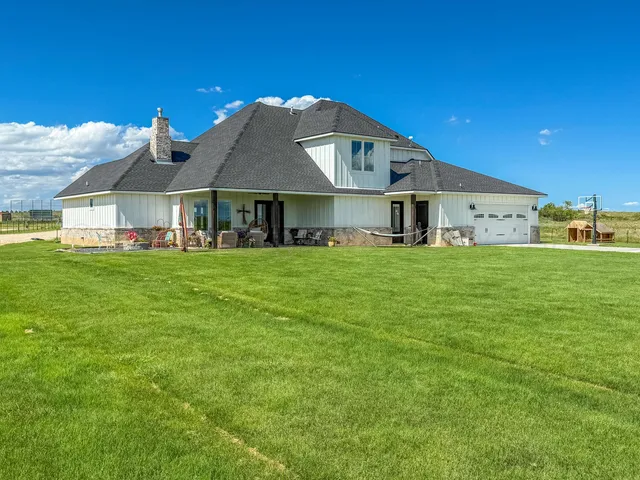 a big white house with a big yard and large trees