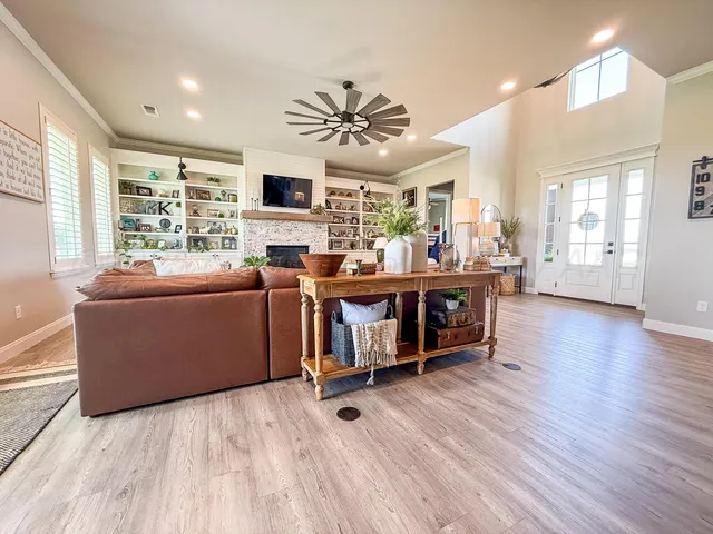 a living room with furniture a wooden floor and a large window