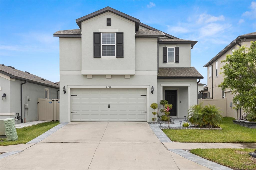 a front view of a house with a yard and garage