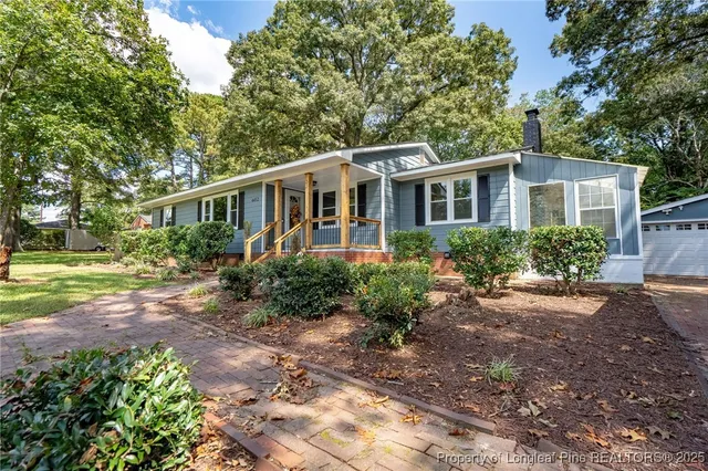 a front view of a house with a yard and trees