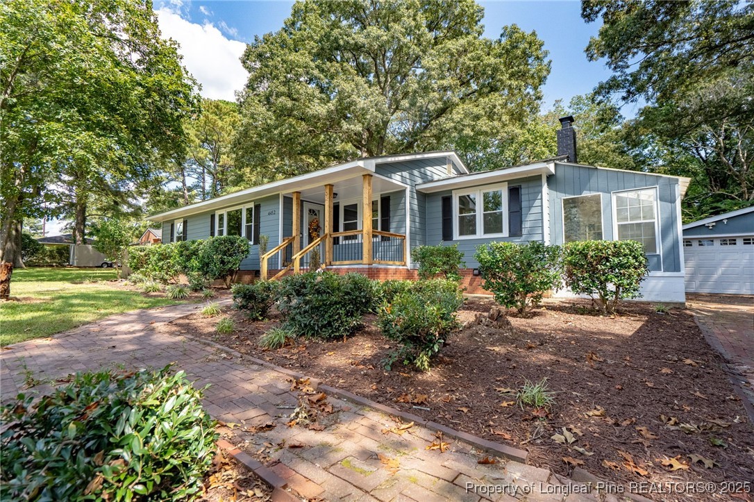 a front view of a house with a yard and trees