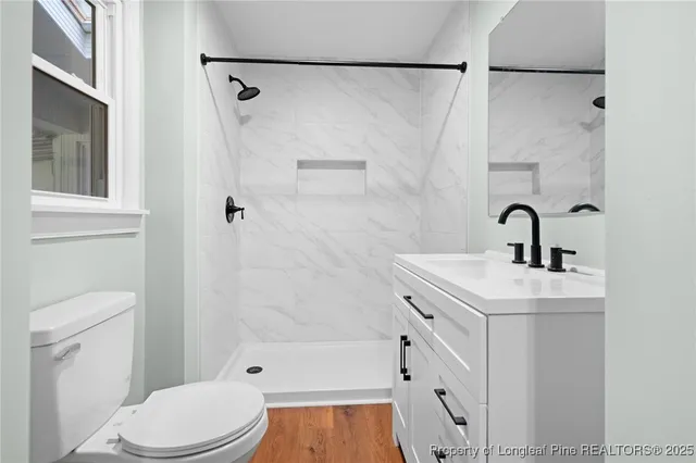 a bathroom with a sink a toilet and shower