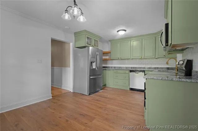 a kitchen with stainless steel appliances granite countertop a refrigerator and a sink