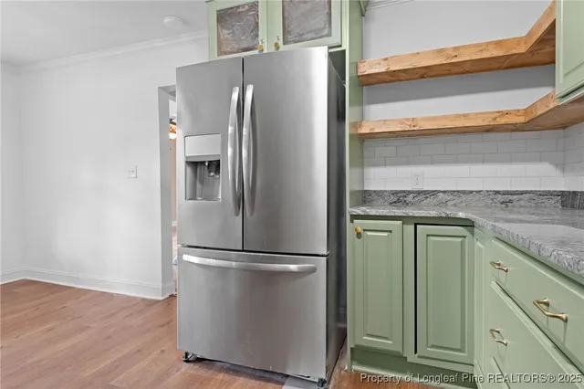a metallic refrigerator freezer sitting in a kitchen