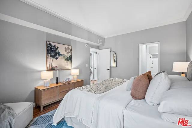 a bedroom with a bed and a painting on the wall