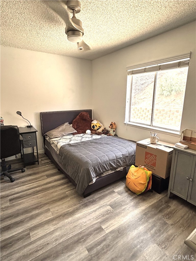 6845 Butte Drive Riverside, CA 92505 - Photo 16 of 27 a bedroom with a bed and dresser with wooden floor