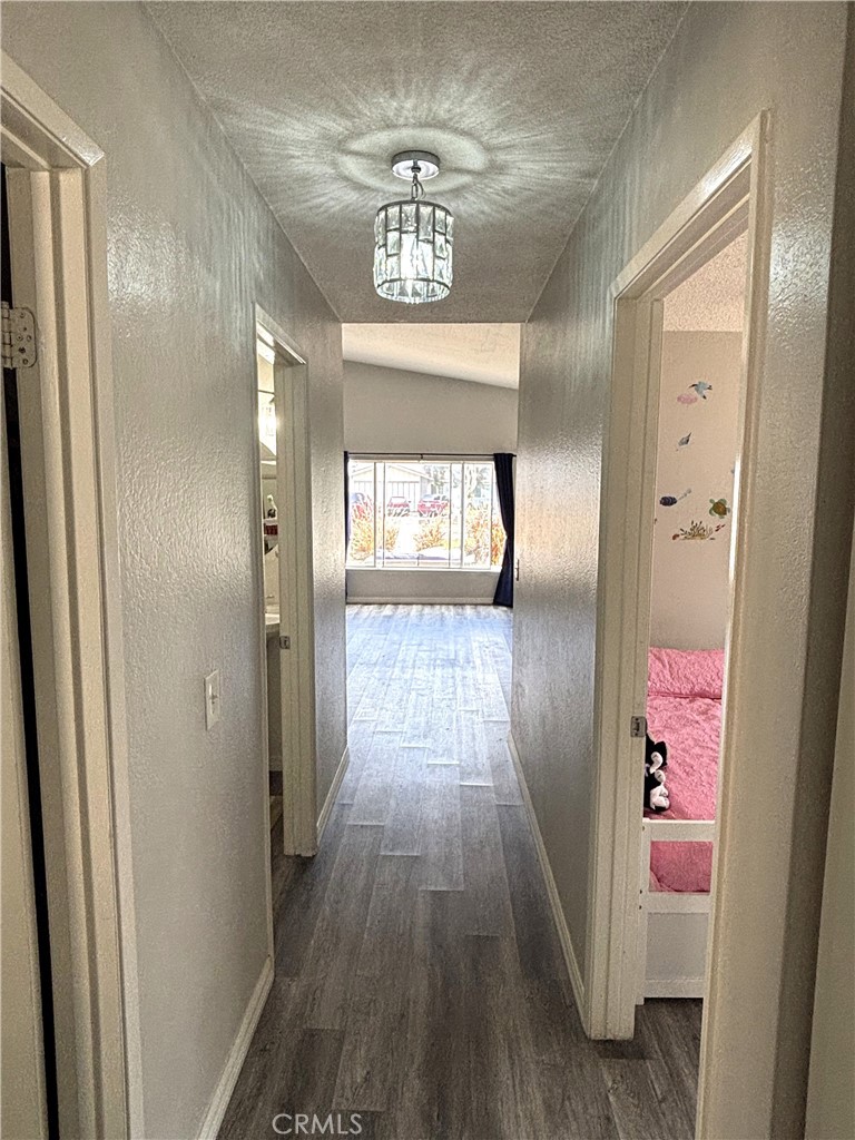 6845 Butte Drive Riverside, CA 92505 - Photo 17 of 27 a hallway with wooden floor chandelier and livingroom