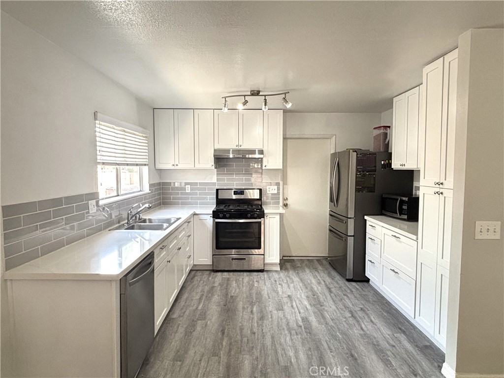 6845 Butte Drive Riverside, CA 92505 - Photo 6 of 27 a kitchen with a sink a counter top space stainless steel appliances and a window