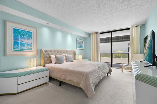 a bedroom with a bed flat screen tv and a large window