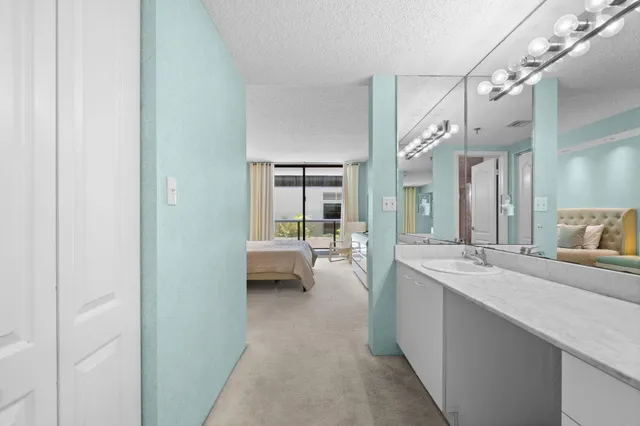 a bathroom with a granite countertop sink a toilet and a large mirror