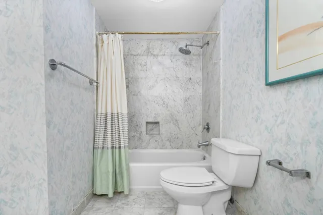 a bathroom with a toilet and a shower