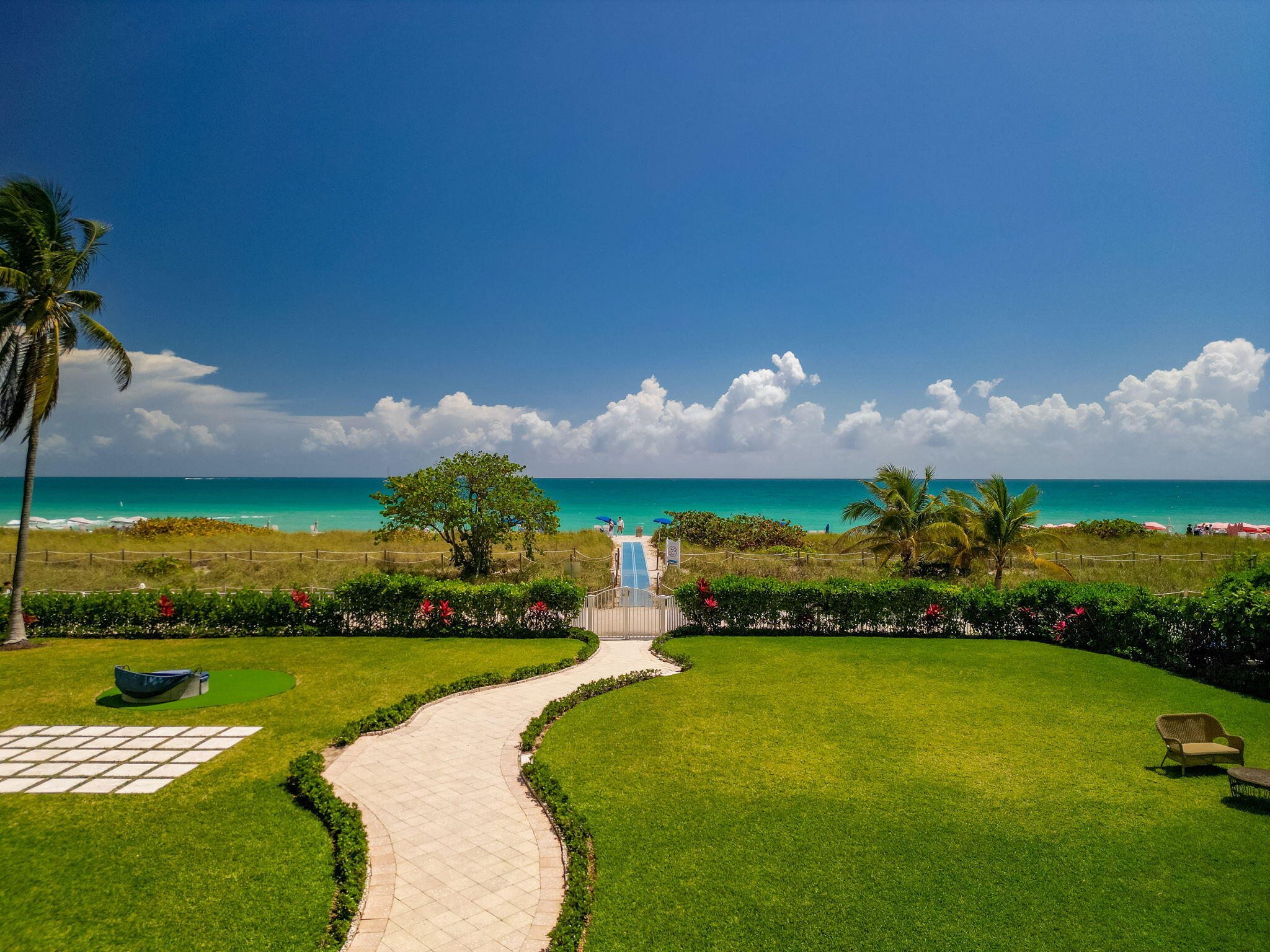 9455 Collins Avenue, Unit 305 Surfside, FL 33154 - Photo 44 of 58 a front view of a house with a garden and yard