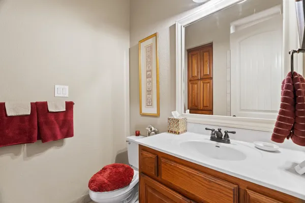 a bathroom with a sink vanity mirror and toilet