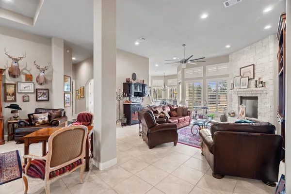 a living room with furniture fireplace and large windows