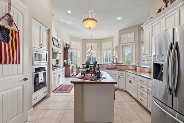 a kitchen with stainless steel appliances kitchen island granite countertop a refrigerator and a stove