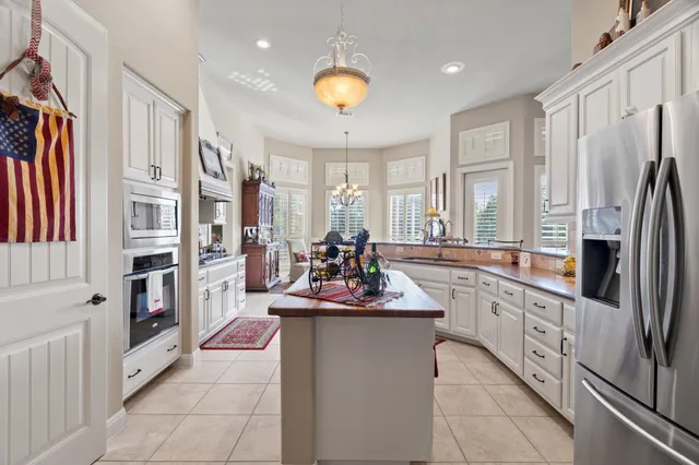 a kitchen with stainless steel appliances kitchen island granite countertop a refrigerator and a stove