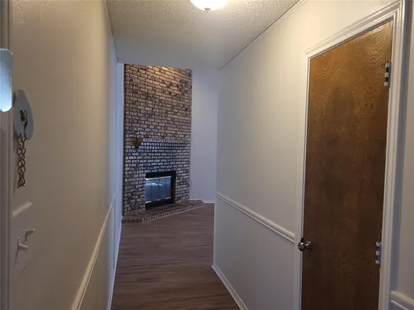 a view of a hallway with wooden floor and a fireplace