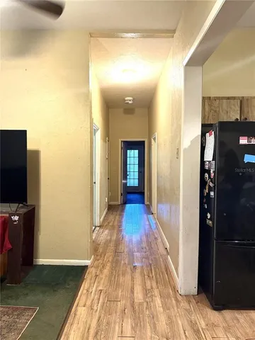 a view of a hallway with wooden floor and furniture