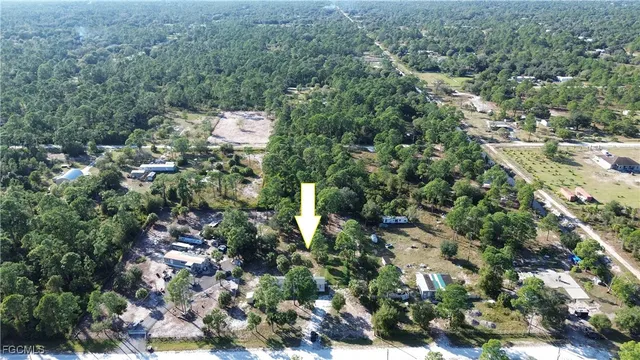 an aerial view of residential house with outdoor space and trees all around