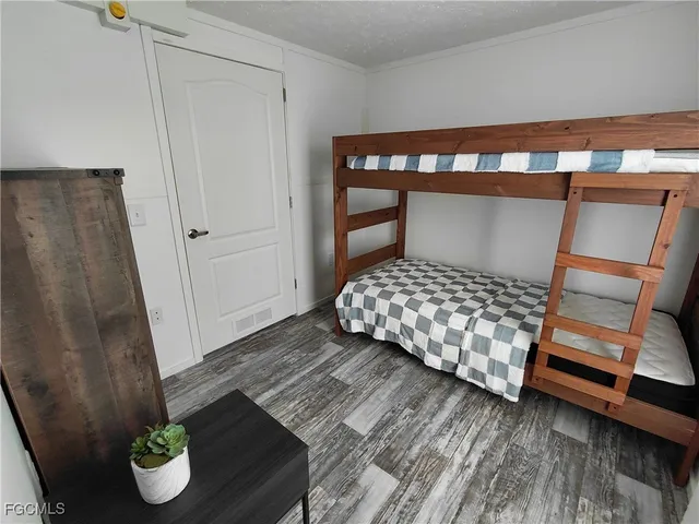 a bedroom with a bed and wooden floor