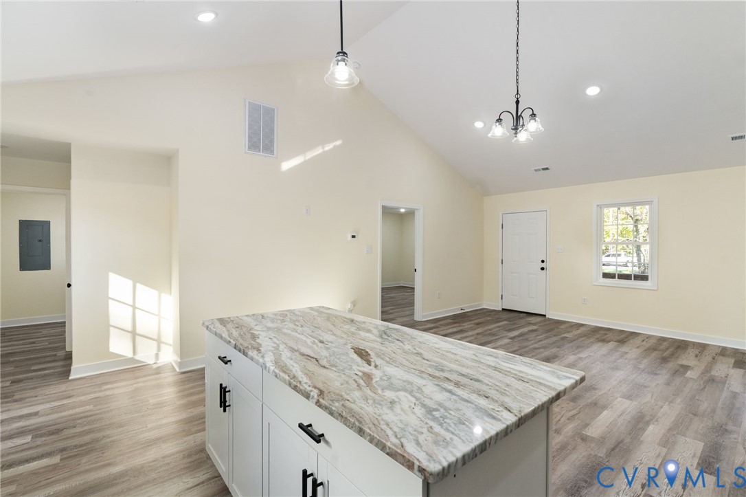 11206 South Crater Road Petersburg, VA 23805 - Photo 11 of 19 an empty room with wooden floor and kitchen view
